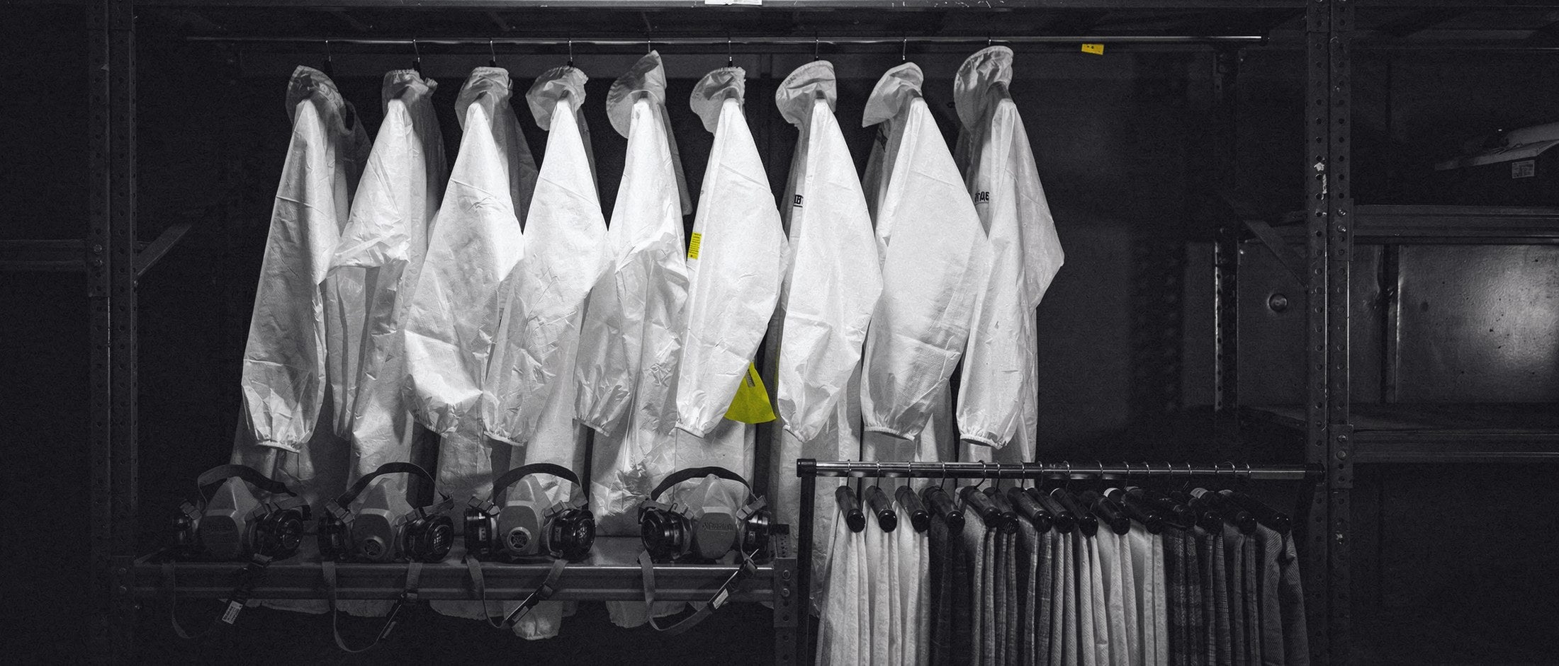 PPE station with paint suits and respirators on hooks